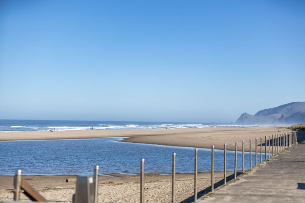 Une promenade en bord de mer avec une plage de sable et une vue sur l’océan.
