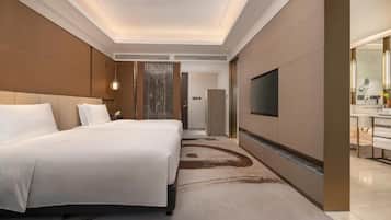 A hotel room with a large bed, a TV mounted on the wall, and a bathroom with a mirror and sink.
