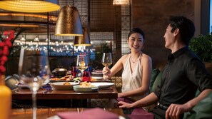 A dining area with a table set for two, a wine glass, and a bowl of food. - Intercontinental Zhengzhou Zhengdong, by IHG (Zhengzhou)
