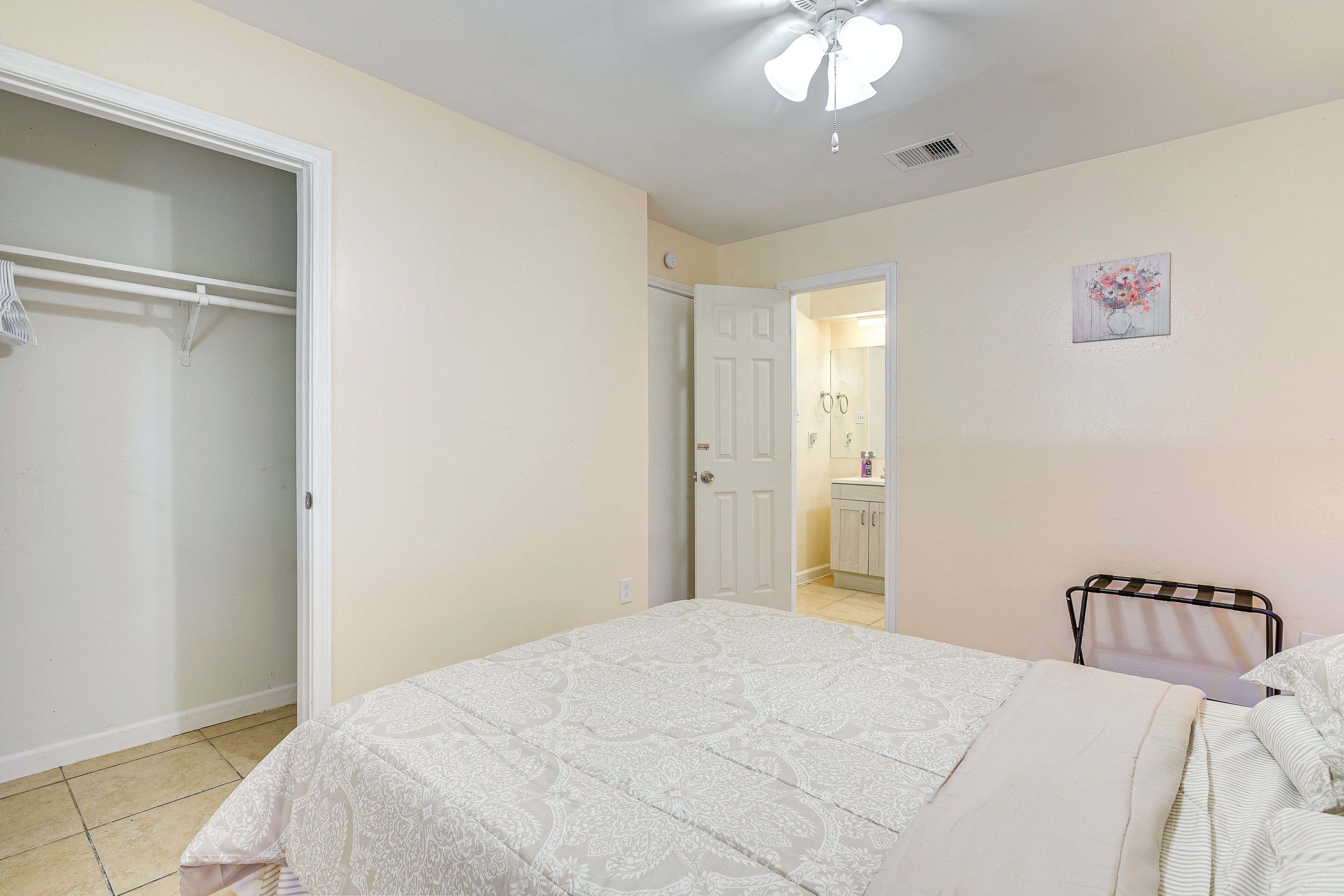 A bedroom with a bed, a wardrobe, and a bathroom visible through an open door.