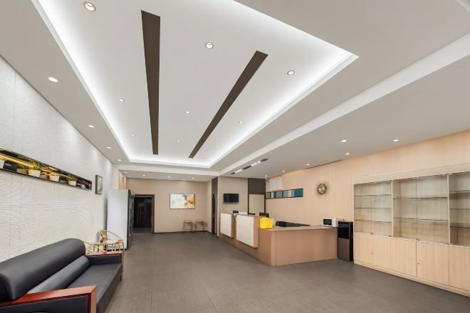 Un área de recepción moderna con mostrador, zona de estar y un ventanal grande.
