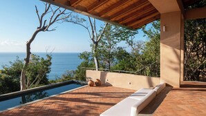 A poolside area with a view of the sea, wooden pergola, and outdoor seating. - Monte LaLaLa - Eco-Lodge à Mermejita - Vue imprenable depuis la piscine! (Oax.)