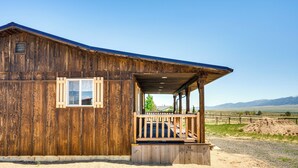 Eine Holzhütte mit Veranda, Fenster und Bergblick.