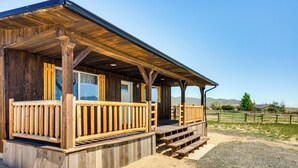 Ein rustikales Holzgebäude mit überdachter Veranda und einem Schotterweg.