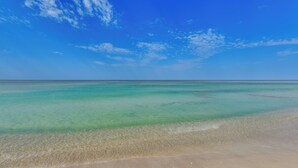 A beach with clear turquoise water and a sandy shore. - Chic & Elevated Decor: Beachfront PCB Gem w/ Patio (Panama City Beach)