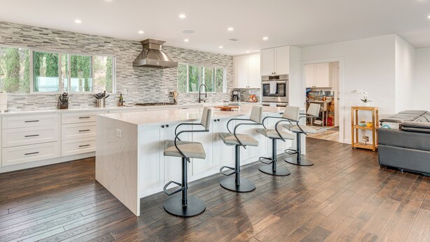 A modern kitchen with a large island, bar stools, and a dining area with a sofa. - 2 Mi to Lake Poway: Mtn-View Escape w/ Patio! (Poway)
