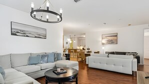 Een moderne woonkamer met een bank, een salontafel en een kroonluchter.