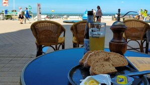 A table with a bottle of Blanch de Namur, slices of bread, butter, and a pepper grinder. - Lovely apartment in Oostende with WiFi (Oostende)