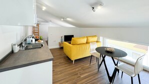 Ein moderner Wohnbereich mit Sofa, Esstisch und Küchenzeile.