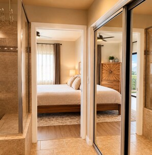 Ein Schlafzimmer mit Bett, Nachttisch, Kommode und Blick ins Freie.