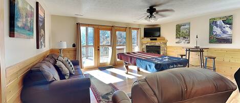 A spacious living area with a sofa, a dining table, and a fireplace.