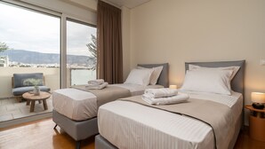 A hotel room with two beds, a view of the city, and a balcony.
