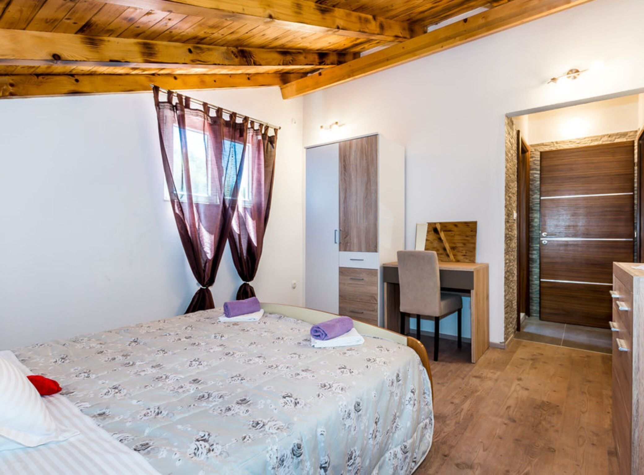 Quarto com cama, escrivaninha e guarda-roupa.