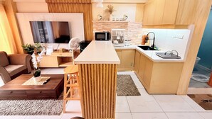 Una cocina moderna con armarios de madera, una isla central y un microondas empotrado.