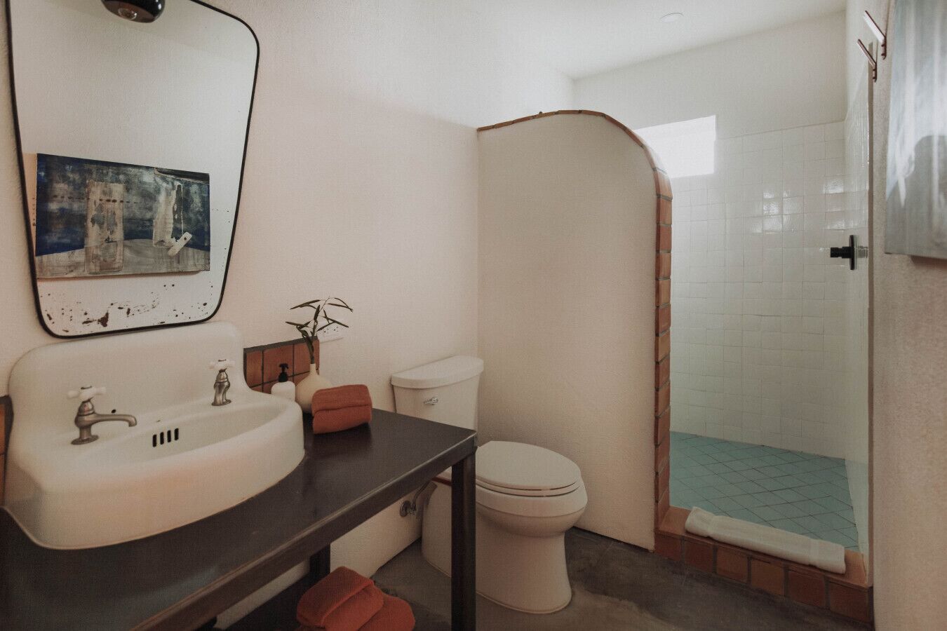 A bathroom with a sink, toilet, and shower area.