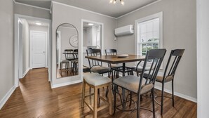 A dining area with a wooden table, six chairs, and a ceiling light fixture.