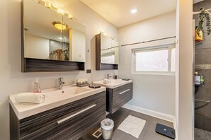 Une salle de bain moderne avec deux lavabos, un grand miroir et une fenêtre.