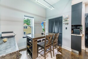 Une cuisine moderne avec une table et des chaises en bois, une fenêtre et un réfrigérateur.