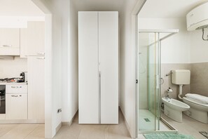 A modern bathroom with a glass shower enclosure, a toilet, and a bidet.