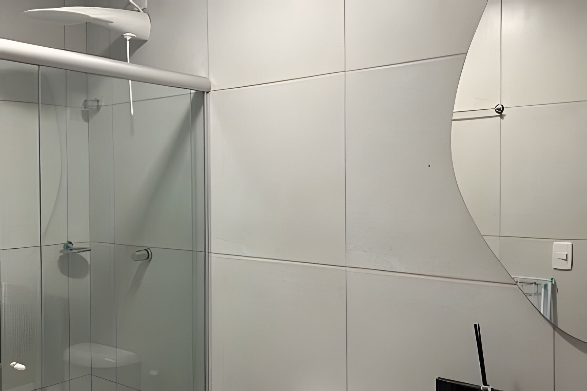 Un baño moderno con cabina de ducha de vidrio, una bañera blanca y un diseño de pared curvada.