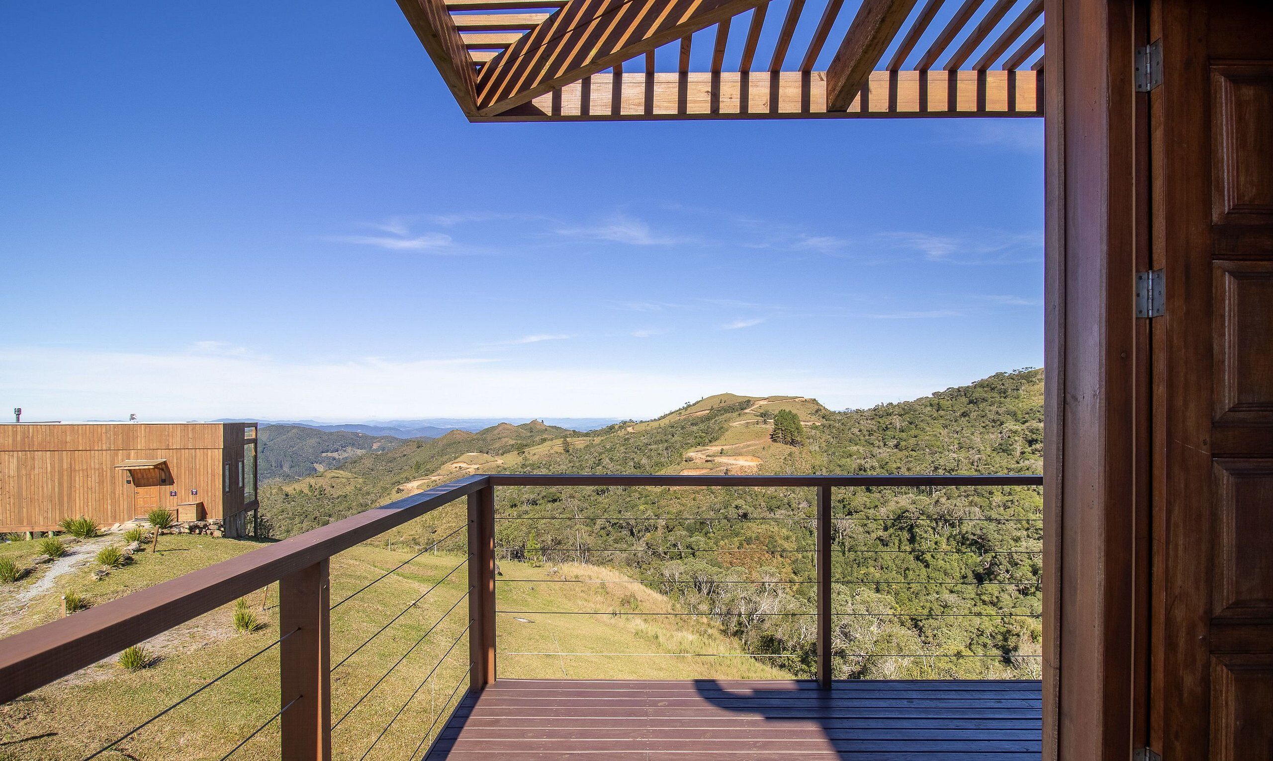 A wooden deck with a view of a hilly landscape.
