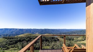 Un balcón de madera con vistas a un paisaje montañoso.