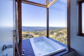 A spa tub with a view of a mountainous landscape. - Linda cabana com jacuzzi VST004 (Anitapolis)
