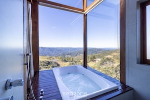 A spa tub with a view of a mountainous landscape. - Linda cabana com jacuzzi VST004 (Anitapolis)