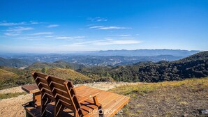 A wooden bench overlooking a mountainous landscape with clear skies. - Linda cabana com jacuzzi VST004 (Anitapolis)