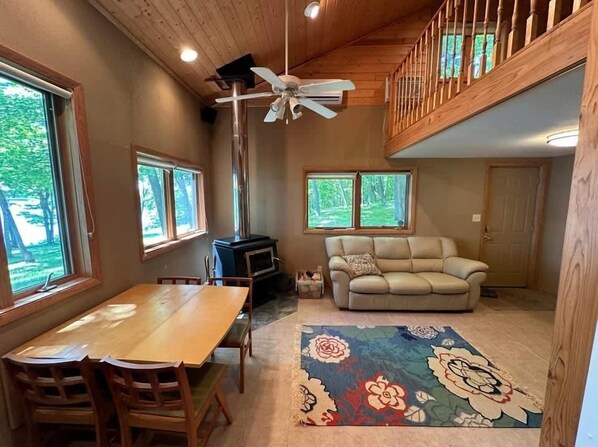 A cozy interior with a dining table, sofa, and a fireplace.