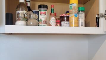 A kitchen shelf with various food items and a knife block.