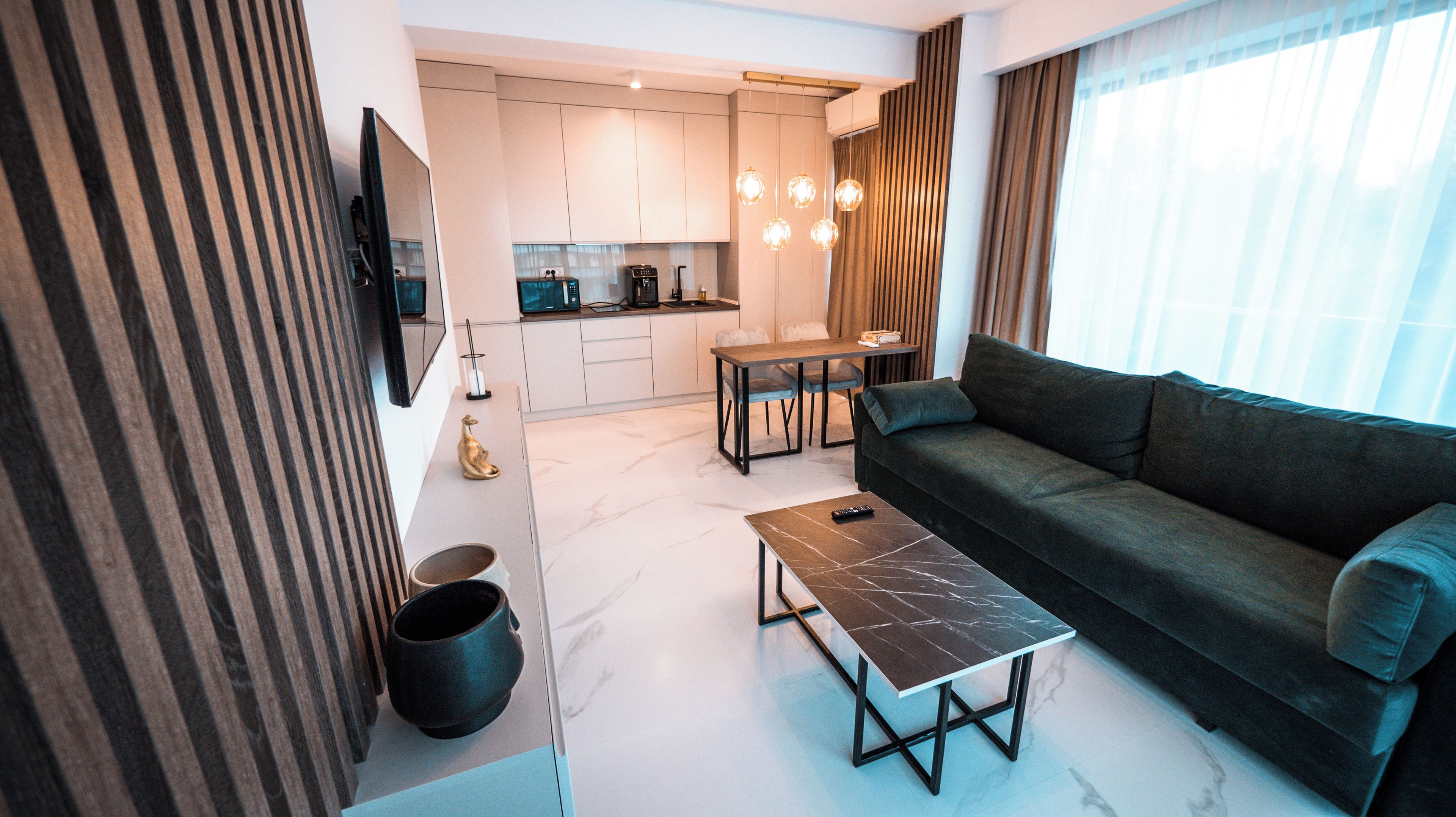 A modern living room with a sofa, a coffee table, and a dining area with chairs.