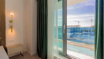 A modern hotel room with a view of a construction site through the window.