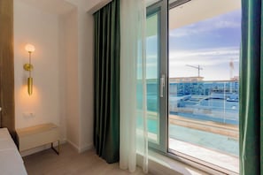 Et moderne hotelværelse med udsigt til et byggeplads igennem vinduet.