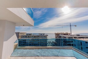 A rooftop terrace with a clear view of the sea and a construction crane in the distance. - Wave 4 Apartments (Navodari)