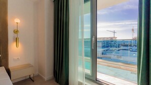 Habitación de hotel moderna con vista a una obra en construcción a través del ventanal.