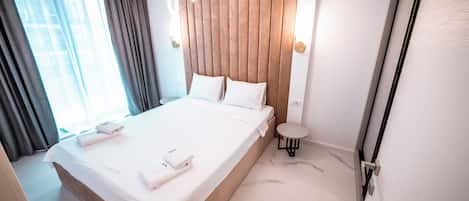 Una habitación de hotel con una cama, una mesita y una silla.