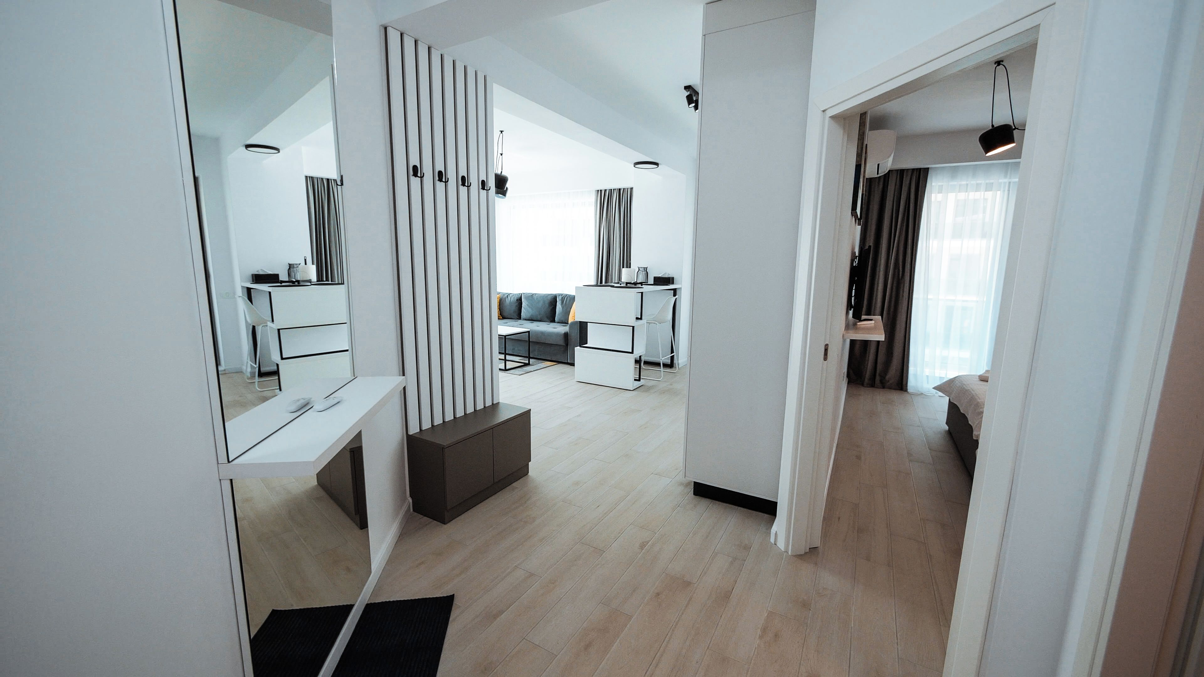 Een moderne, open woonkamer met een bank, een eettafel en een keukenhoek.