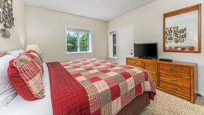 A bedroom with a bed, a dresser, a television, and a window. - Holly Ridge 102 | Cozy, Near Gatlinburg + Privacy (Gatlinburg)