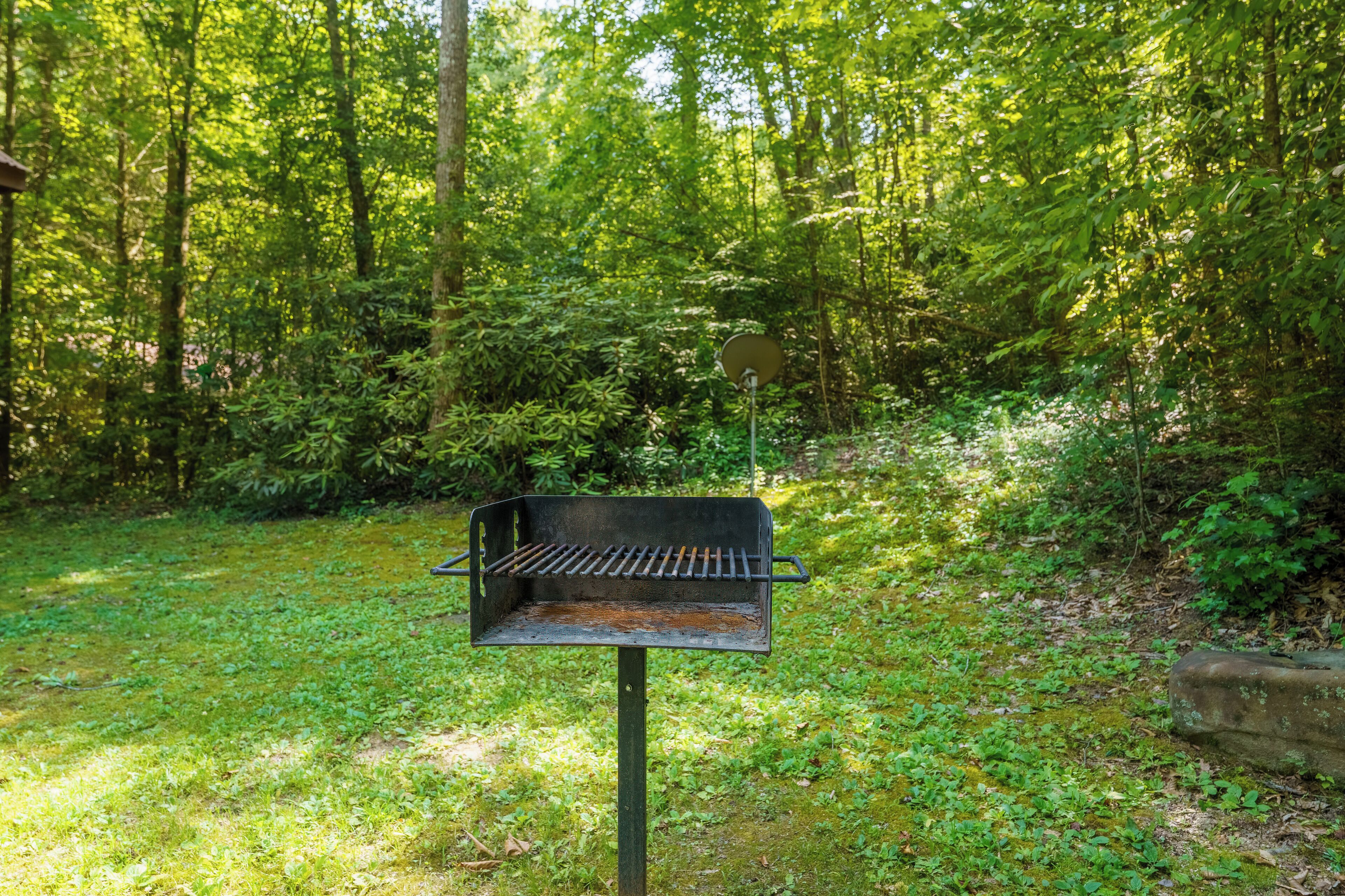 A barbecue grill in a wooded area.