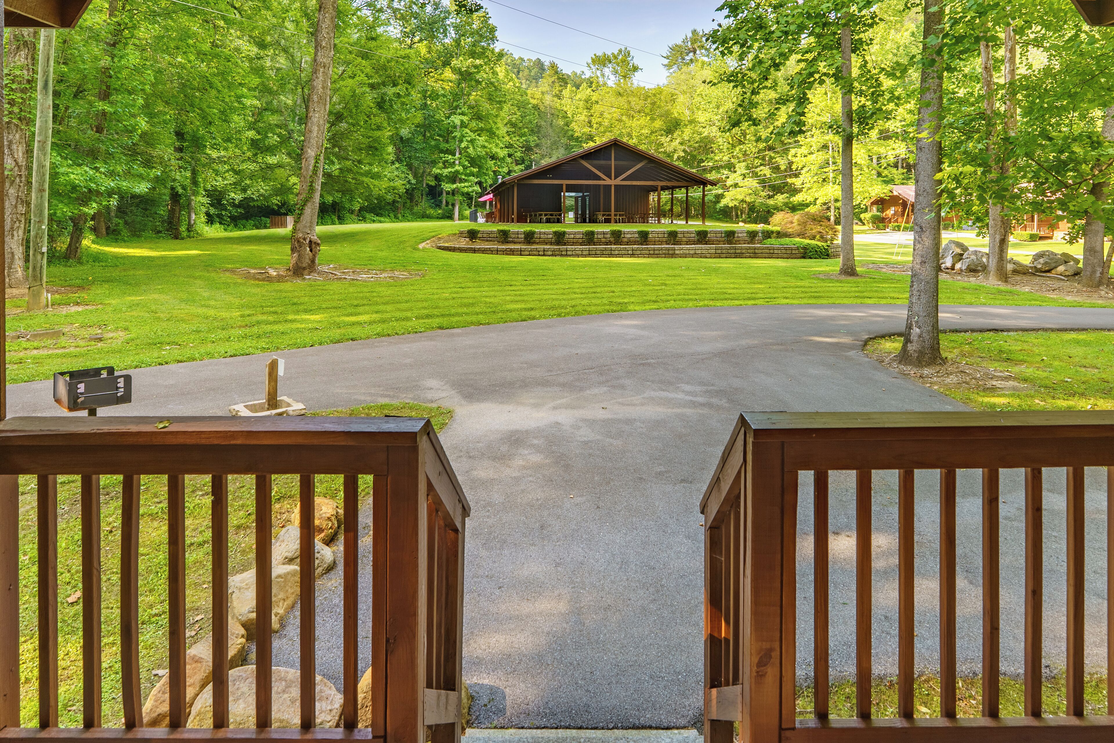 A wooden gate leading to a covered outdoor area with a building in the background.