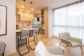 A modern kitchen with a dining area, a large window with curtains, and a minimalist design. - Digital Nomad Paradise 2BR unit with A/C in Manila (Medellín)