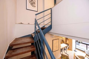 A wooden staircase with blue railings leading to a lower level. - Digital Nomad Paradise 2BR unit with A/C in Manila (Medellín)