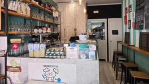 A cozy cafe with a wooden counter, shelves with glassware, and a menu board. - Pippo a vernazza rooms (Vernazza)