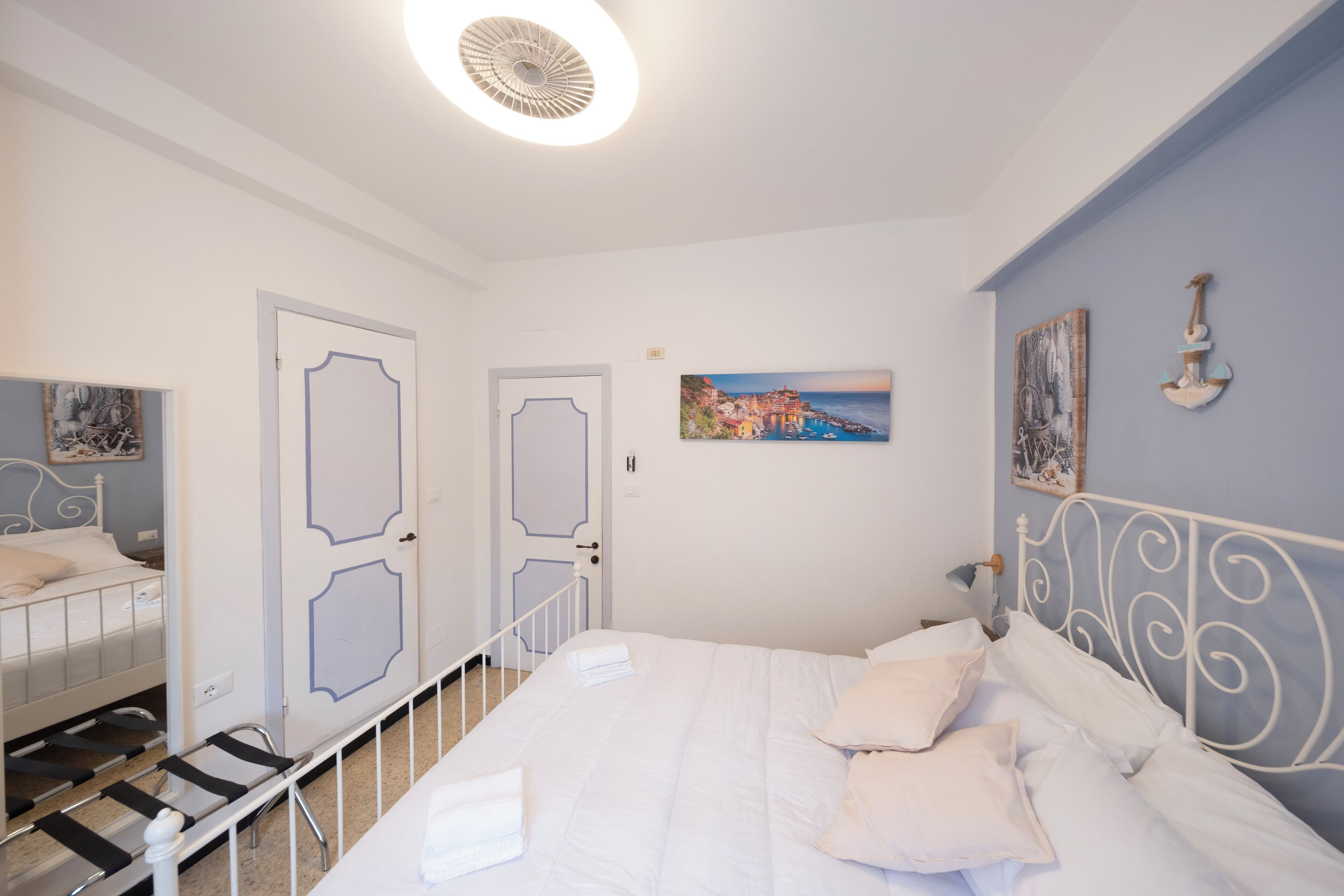 Ein Schlafzimmer mit einem Bett, zwei Türen, einer Treppe und einem Bild an der Wand.