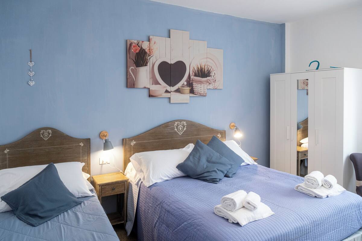 Une chambre d’hôtel avec deux lits, une armoire et un mur décoré.