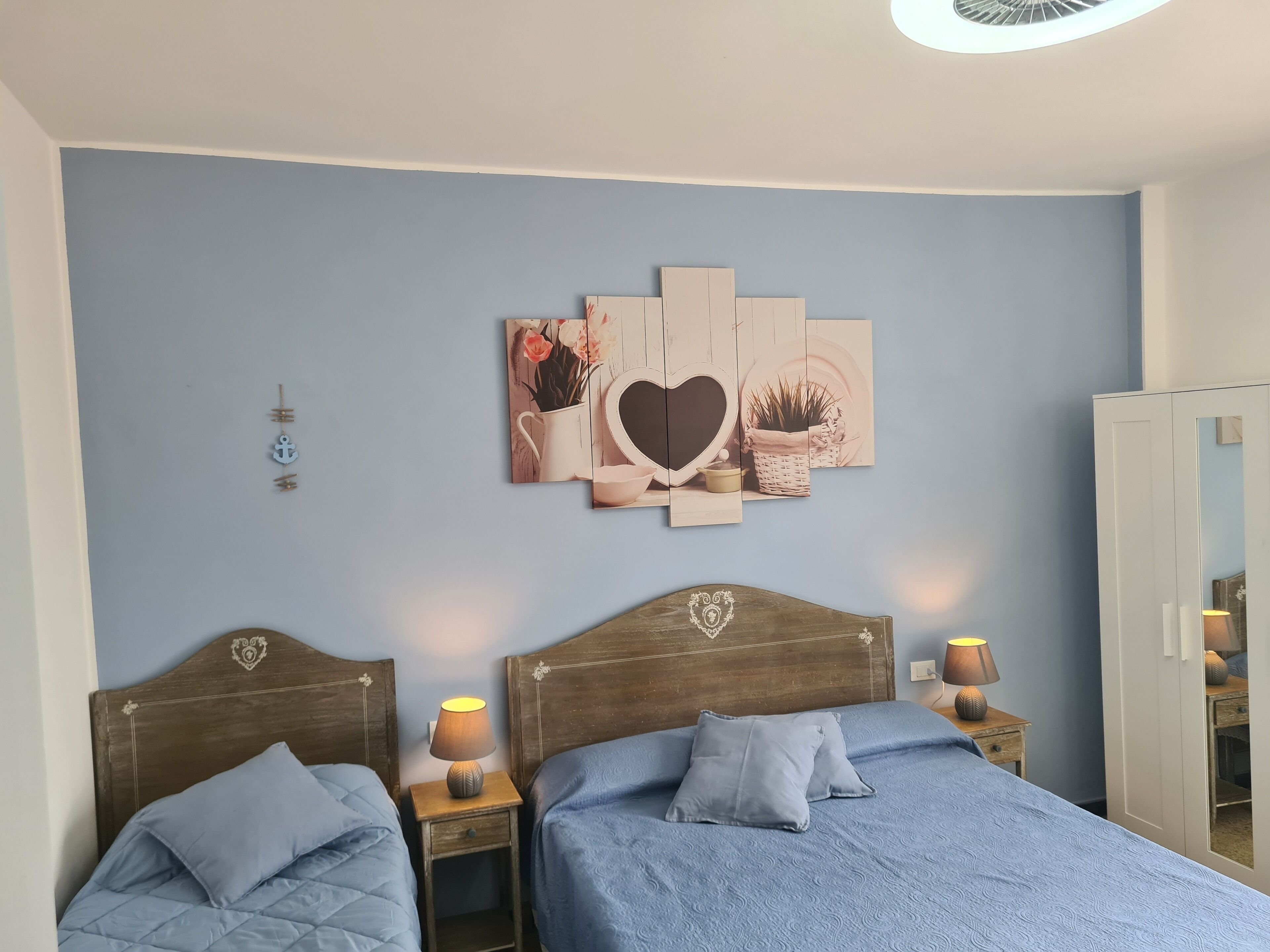 Un dormitorio con dos camas, una obra de arte en la pared y un armario.