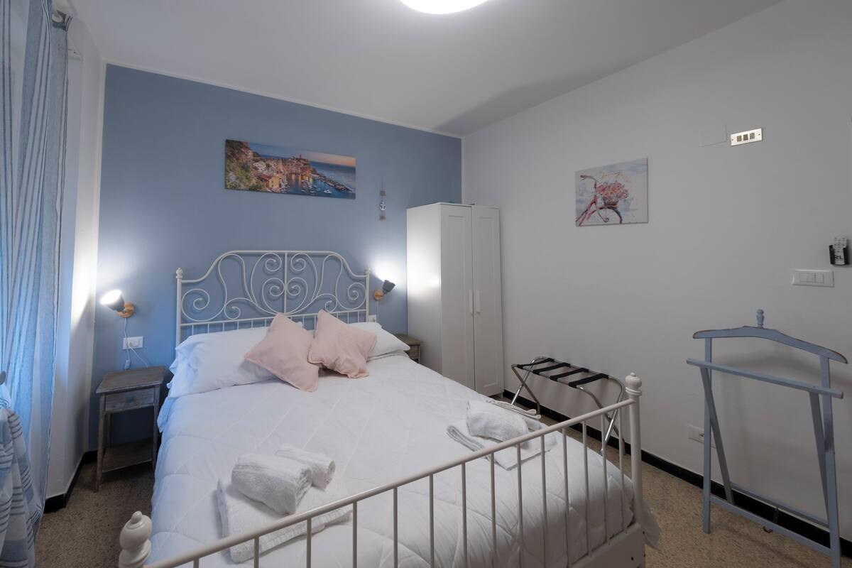 Une chambre à coucher avec un lit, une armoire, une table de chevet, une lampe et un tableau au mur.