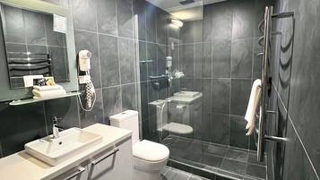 A modern bathroom with a glass-enclosed shower, a white sink, and a toilet.