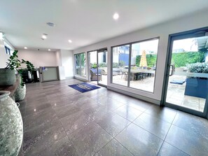A spacious lobby with a reception desk, large windows, and a blue mat with "Crown on Darby" text. - Crown On Darby (Newcastle)